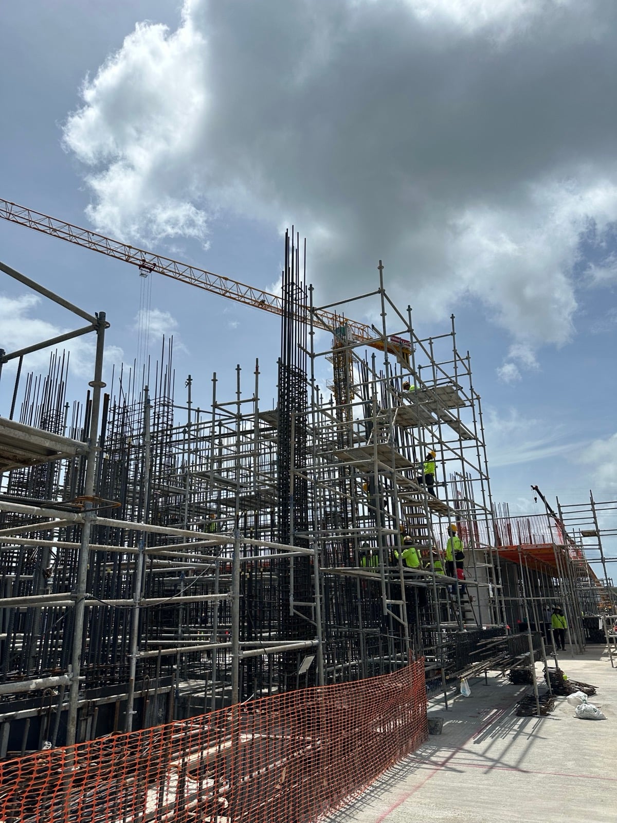 Workers on scaffolding towers building structural columns