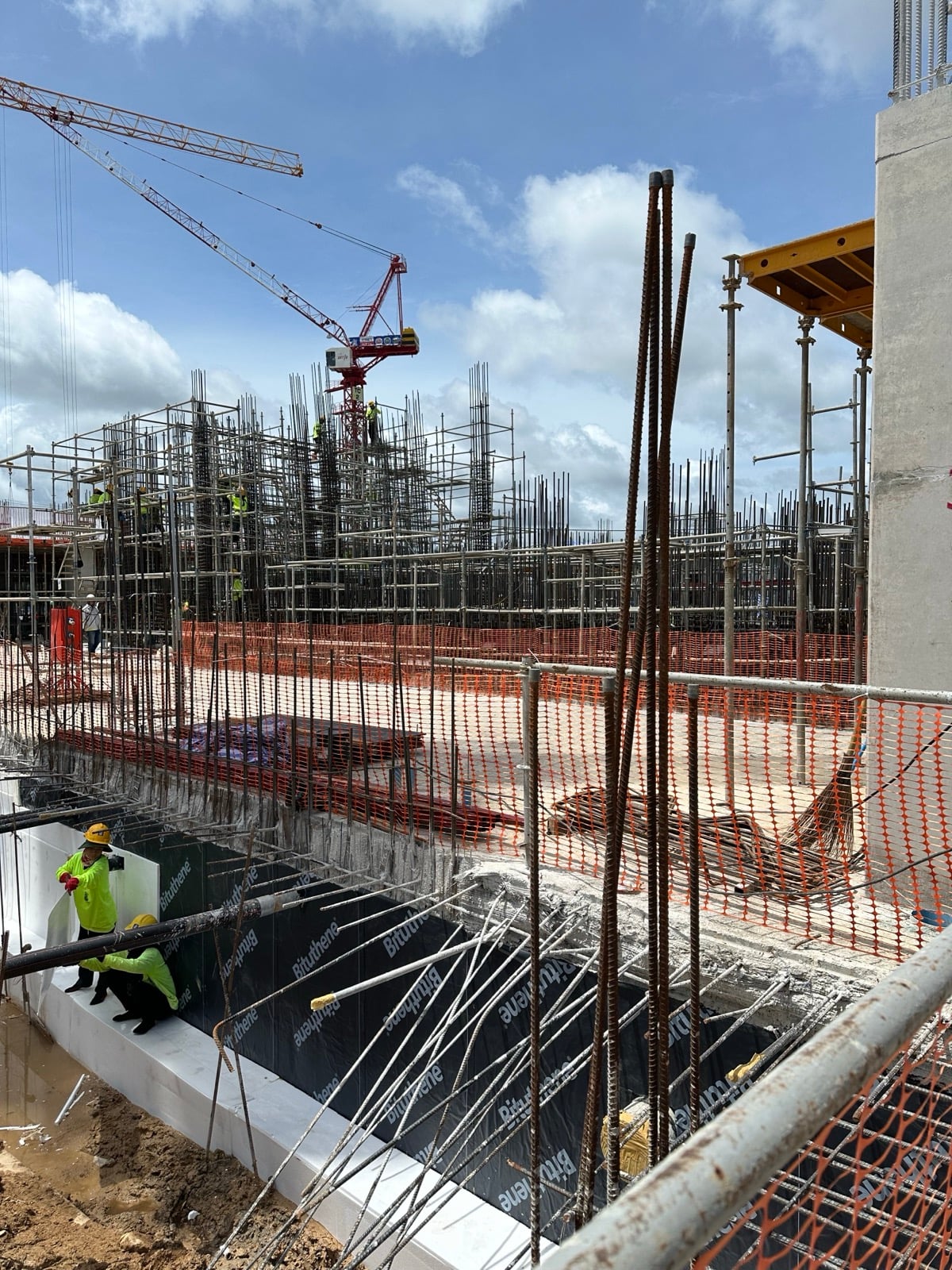 Waterproofing membrane and reinforcement dowels on a below-grade retaining wall